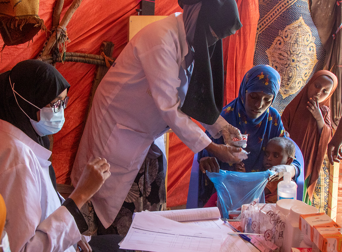 Deux doctoresses donnent des médicaments à une femme et ses deux filles dans une clinique mobile.