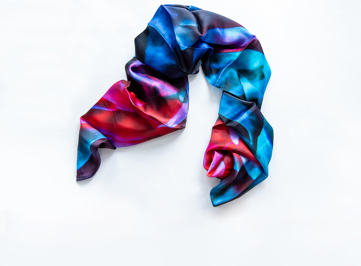 Une écharpe en satin aux teintes bleues, roses, rouges et violettes éclatantes.